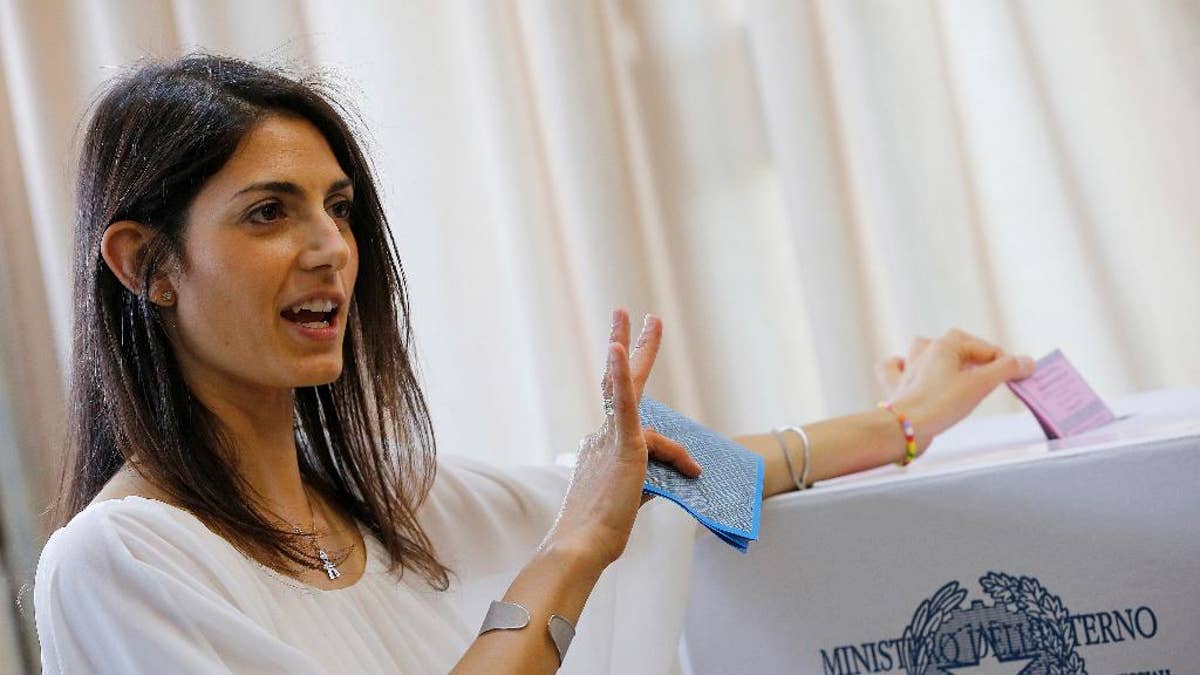 Anti-establishment 5-Star Movement (M5S) candidate as Rome's mayor Virginia Raggi poses for photographers as she casts her ballot in polling station in Rome, Sunday, June 19, 2016. Mayoral runoffs are held in Rome, Milan and other big Italian cities Sunday. If Raggi wins, she'll be the first woman to serve as Rome mayor. (AP Photo/Fabio Frustaci)