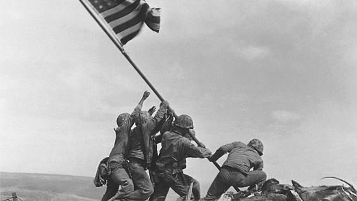 U.S. Marines of the 28th Regiment, 5th Division, raise the American flag atop Mt. Suribachi, Iwo Jima, on Feb. 23, 1945. Strategically located only 660 miles from Tokyo, the Pacific island became the site of one of the bloodiest, most famous battles of World War II against Japan.  (AP Photo/Joe Rosenthal)