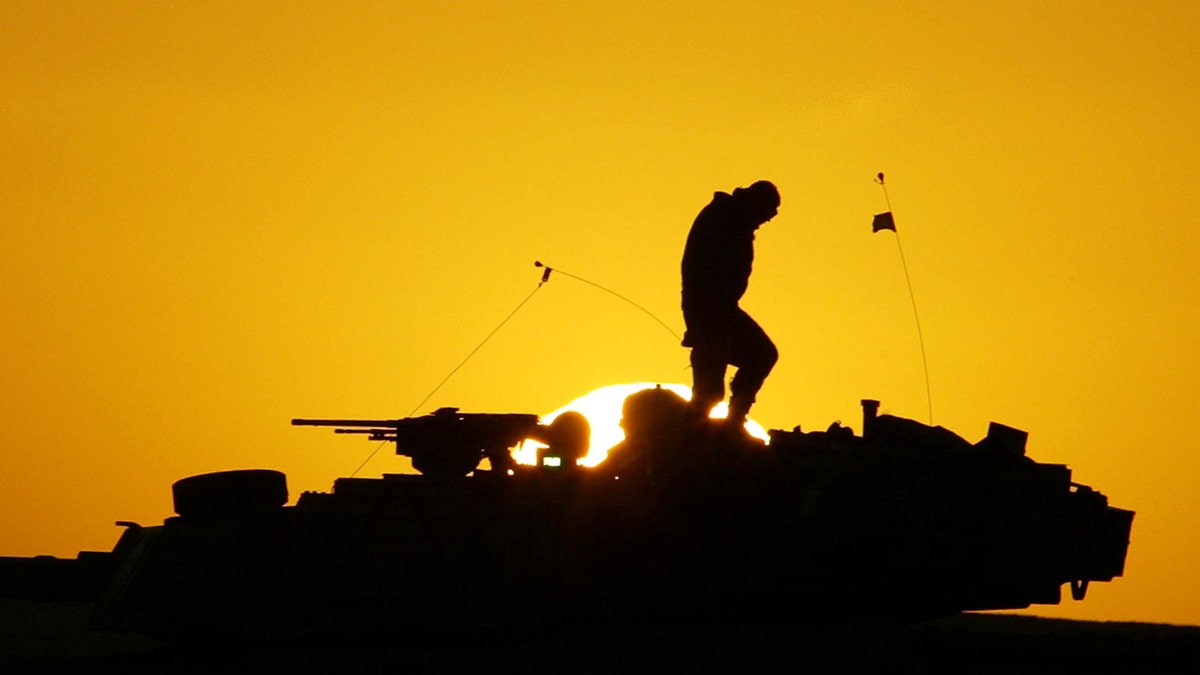 FILE - A U.S. soldier walks atop his armored vehicle at sunset as he prepares for a nighttime military exercise in the Kuwaiti desert south of the Iraqi border on Sunday, Dec. 22, 2002. Combat appears to have little or no influence on suicide rates among U.S. troops and veterans, according to a military study that challenges the conventional thinking about warâs effects on the psyche published Tuesday, Aug. 6, 2013 in the Journal of the American Medical Association. (AP Photo/Anja Niedringhaus)