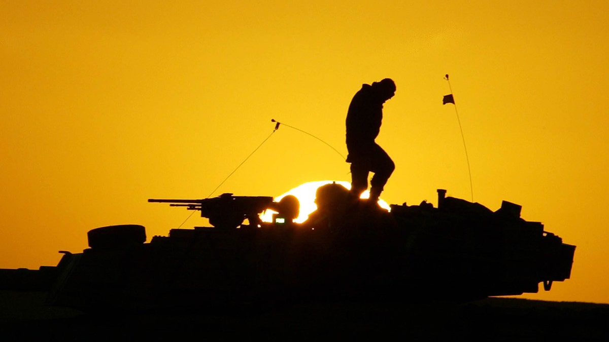 FILE - A U.S. soldier walks atop his armored vehicle at sunset as he prepares for a nighttime military exercise in the Kuwaiti desert south of the Iraqi border on Sunday, Dec. 22, 2002. Combat appears to have little or no influence on suicide rates among U.S. troops and veterans, according to a military study that challenges the conventional thinking about warâs effects on the psyche published Tuesday, Aug. 6, 2013 in the Journal of the American Medical Association. (AP Photo/Anja Niedringhaus)