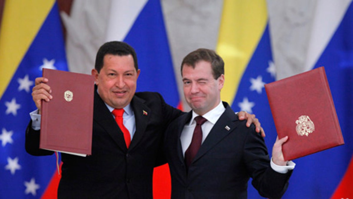 Russian President Dmitry Medvedev, right, and his Venezuelan counterpart Hugo Chavez show signed documents during their meeting in Moscow, Russia, Friday, Oct. 15, 2010. Chavez reached a deal with Russia on Friday to build the South American country's first nuclear plant and negotiated other energy agreements. Medvedev sought to preempt questions about why the Venezuela rich in oil and gas would need nuclear power by saying the deal would help Caracas reduce its dependence on global market fluctuations.  (AP Photo/Alexander Zemlianichenko)