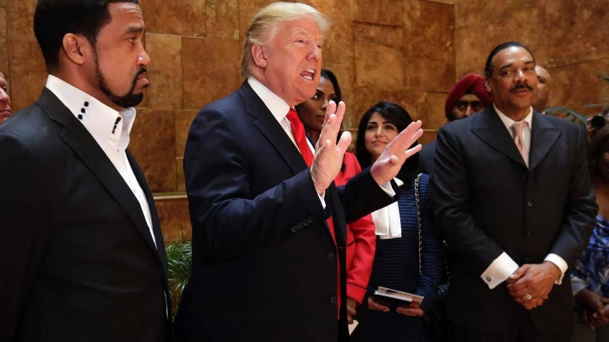 FILE - In this April 18, 2016 file photo, Pastor Darrell Scott listens at left as Republican presidential candidate Donald Trump speaks in Trump Tower building in New York. Competing appearances earlier this month by Trump and Hillary Clinton highlight an oft-overlooked political reality: The “religious vote” is vast and complex, and it extends beyond generalizations about “social conservatives” who side with Republicans and black Protestant churches whose pastors and parishioners opt nearly unanimously for Democrats. (AP Photo/Richard Drew, File)