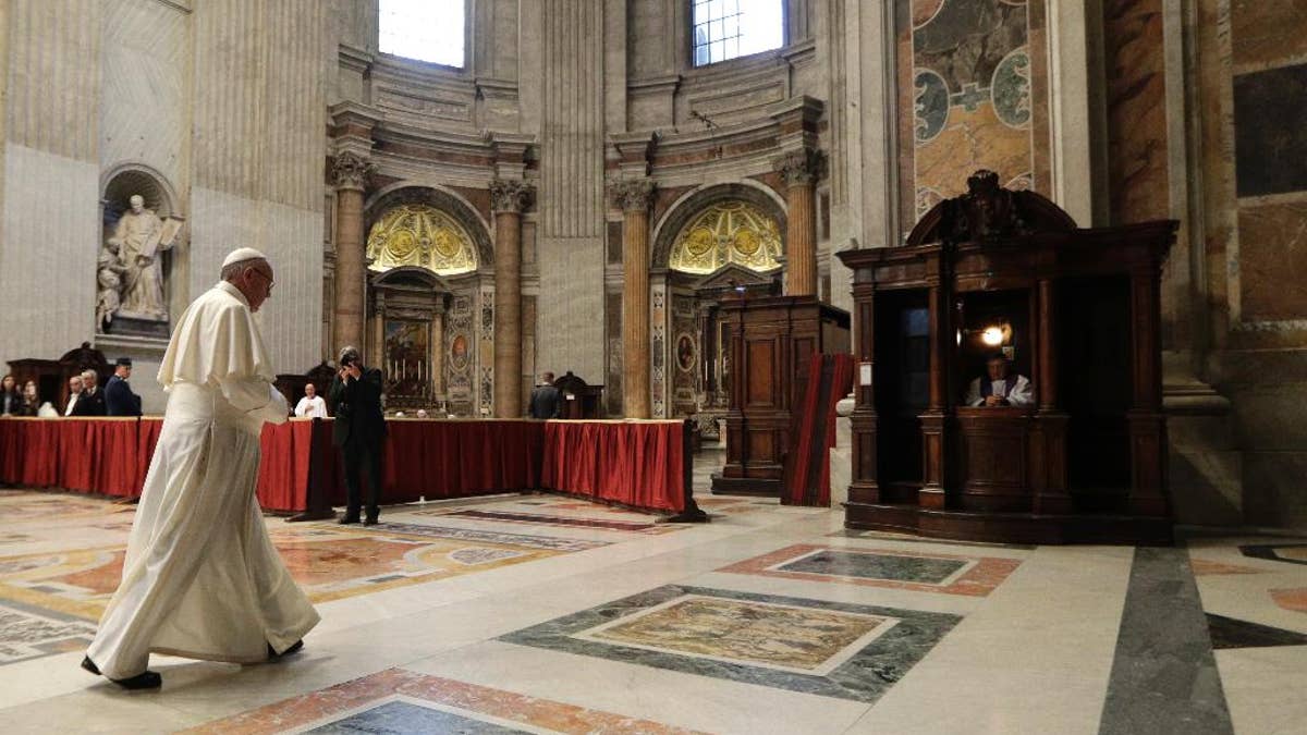 Pope Francis walks toward a confessional box during a penitential liturgy in St. Peter's Basilica at the Vatican, Friday, March 17, 2017. (AP Photo/Andrew Medichini, Pool)