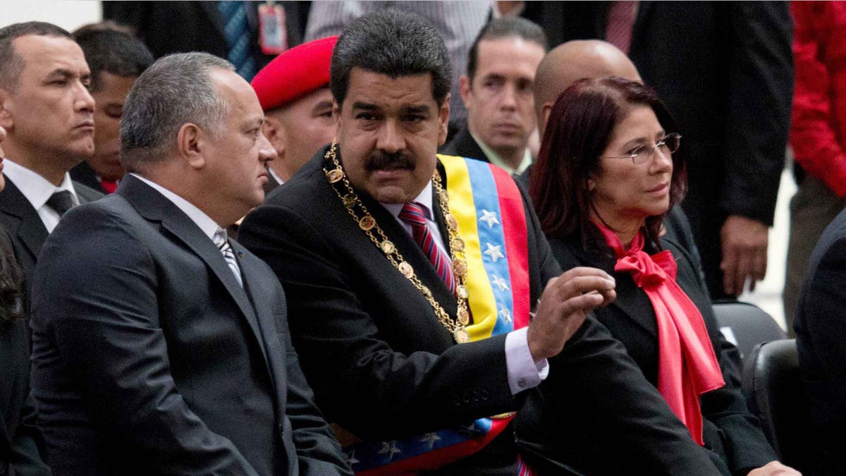 El presidente venezolano NicolÃ¡s Maduro, al centro, habla con Diosdado Cabello, presidente de la Asamblea Nacional, izquierda, durante una ceremonia para conmemorar el 185to aniversario de la muerte del hÃ©roe independentista SimÃ³n Bolivar en Caracas, Venezuela, el jueves 17 de diciembre de 2015. La mujer a la derecha es la primera dama Cilia Flores. (Foto AP/Fernando Llano)