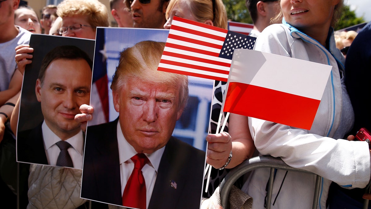 People holding portraits of U.S. President Donald Trump and Polish President Andrzej Duda wait for U.S. President Donald Trump's public speech at Krasinski Square, in Warsaw, Poland July 6, 2017. REUTERS/Kacper Pempel - RTX3A9OB