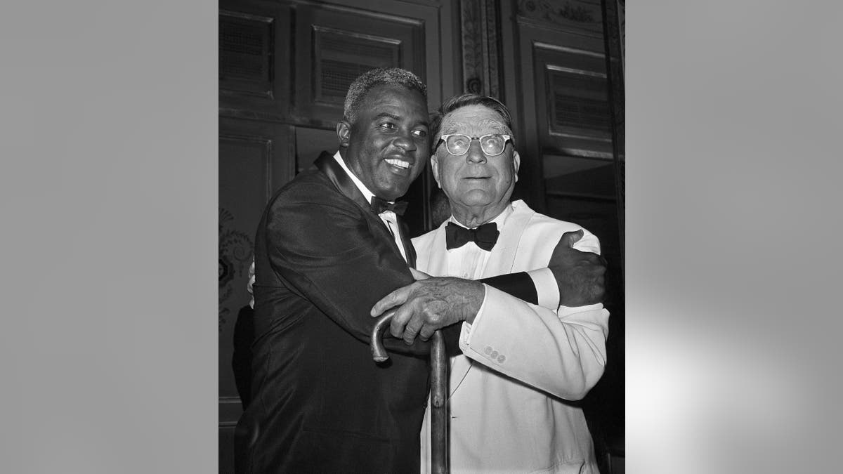 FILE - In this July 20, 1962 file photo, baseball player Jackie Robinson embraces Branch Rickey in New York. Rickey was general manager of the Brooklyn Dodgers when Robinson was hired. The home area of the late baseball executive Rickey expects increased interest in his southern Ohio roots from his depiction in the movie “42,” in which Harrison Ford plays the man who signed Jackie Robinson to challenge baseball’s color line. (AP Photo/File)
