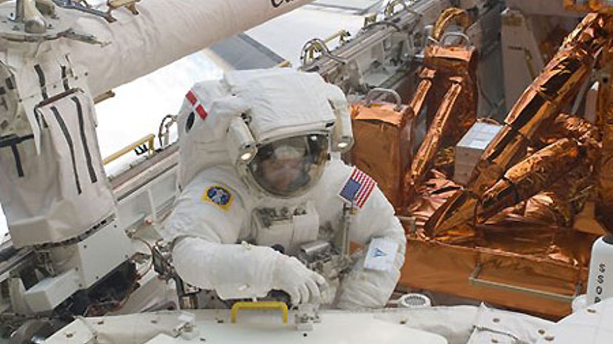 Astronaut Mike Massimino is photographed during extravehicular activity to refurbish and upgrade the Hubble Space Telescope.