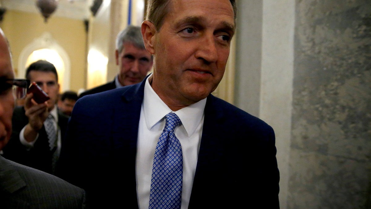 U.S. Senator Jeff Flake (R-AZ) walks past journalists after announcing he will not run for reelection on Capitol Hill in Washington, DC, U.S. October 24, 2017. REUTERS/Joshua Roberts - RC115CA83EE0