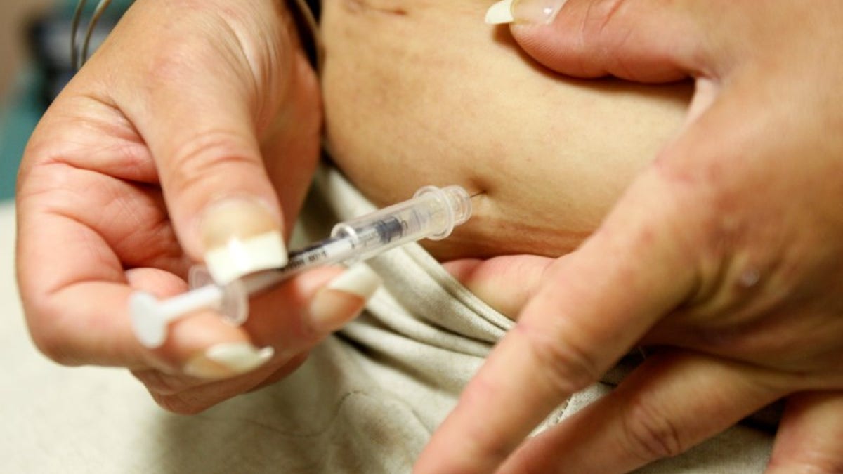 Diabetic Khachatoorian injects herself with insulin at the J.W.C.H. safety-net clinic in downtown Los Angeles