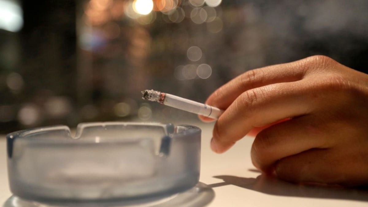 A customer smokes a cigarette in a cafe in Prague