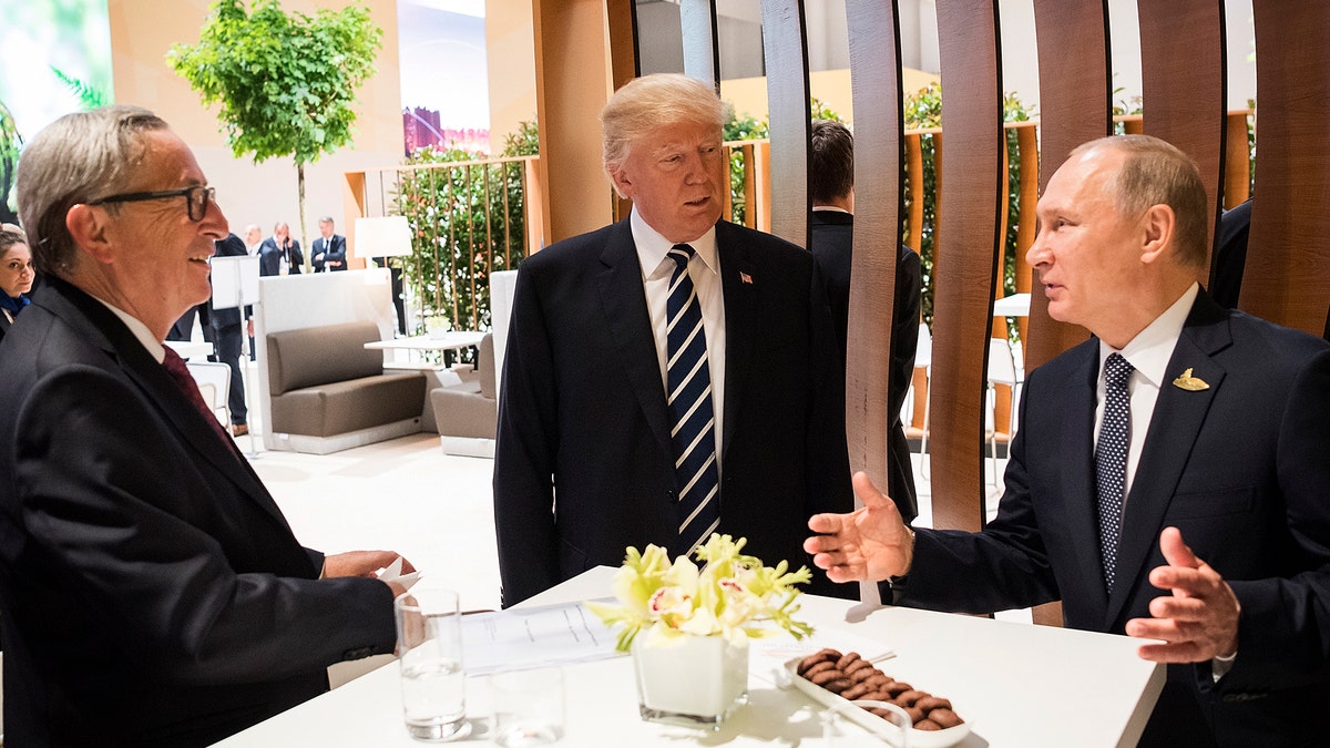 In this photo provided by German government U.S. President Donald Trump, center, talks to Russian President Vladimir Putin and European Commission President Jean-Claude Juncker, left, before the first working session of the G-20 summit in Hamburg, northern Germany. (Steffen Kugler/Presse- und Informationsamt der Bundesregierung via AP)