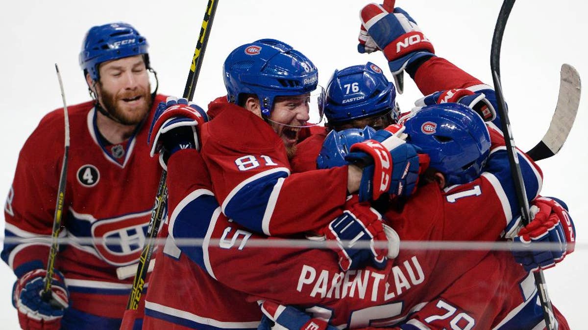 Montreal Canadiens right wing P.A. Parenteau (15) celebrates with teammates Andrei Markov (79), P.K. Subban (76), Lars Eller(81) and Brandon Prust, left, after scoring the winning goal against the Tampa Bay Lightning during the third period of Game 5 of a second-round NHL Stanley Cup hockey playoff series Saturday, May 9, 2015, in Montreal. (Ryan Remiorz/The Canadian Press via AP) MANDATORY CREDIT