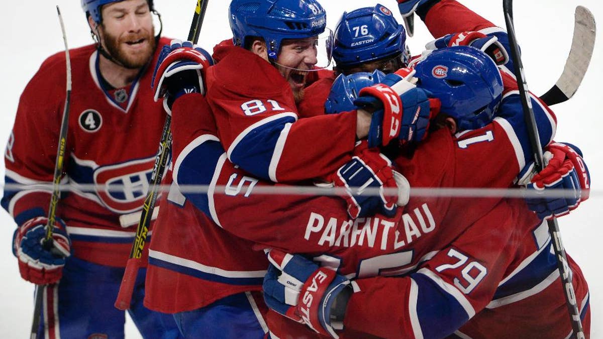 Montreal Canadiens right wing P.A. Parenteau (15) celebrates with teammates Andrei Markov (79), P.K. Subban (76), Lars Eller(81) and Brandon Prust, left, after scoring the winning goal against the Tampa Bay Lightning during the third period of Game 5 of a second-round NHL Stanley Cup hockey playoff series Saturday, May 9, 2015, in Montreal. (Ryan Remiorz/The Canadian Press via AP) MANDATORY CREDIT