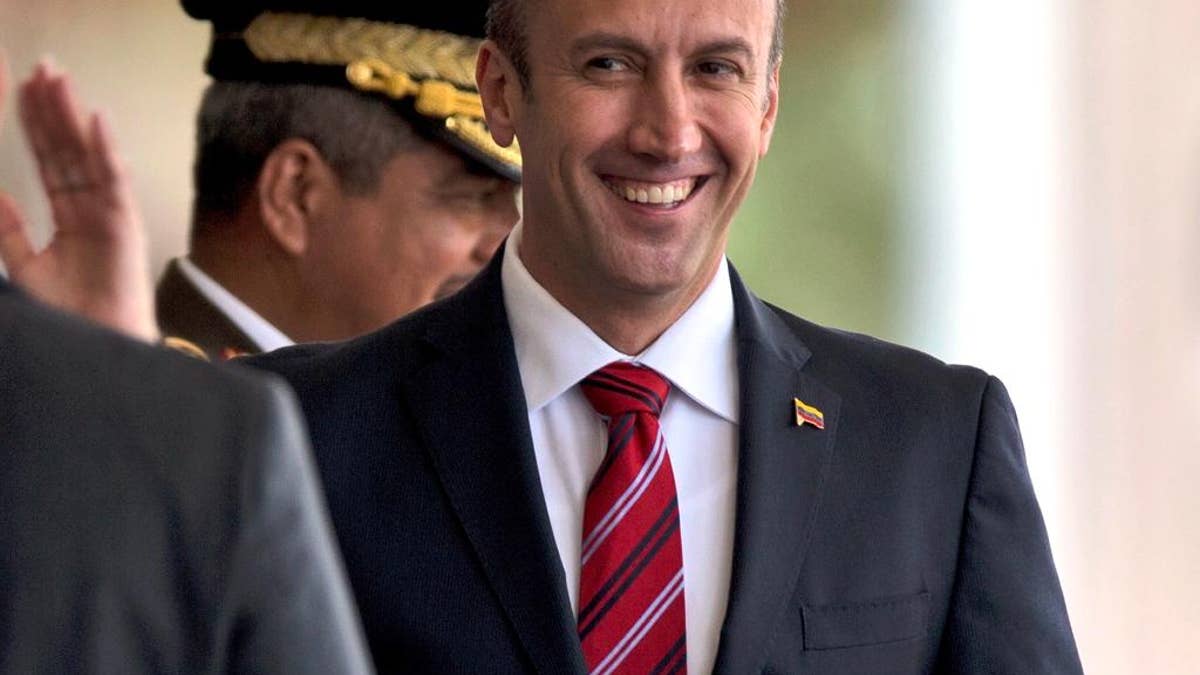 FILE - In this Feb. 1, 2017 photo, Venezuela's Vice President Tareck El Aissami, right, is saluted by Boilivarian Army officer upon his arrival for a military parade at Fort Tiuna in Caracas, Venezuela. The administration of President Donald Trump is slapping sanctions on El Aissami and accusing him of playing a major role in international drug trafficking. That’s according to individuals briefed on the U.S. government’s plans who requested anonymity to disclose the move ahead of a formal announcement. (AP Photo/Fernando Llano)