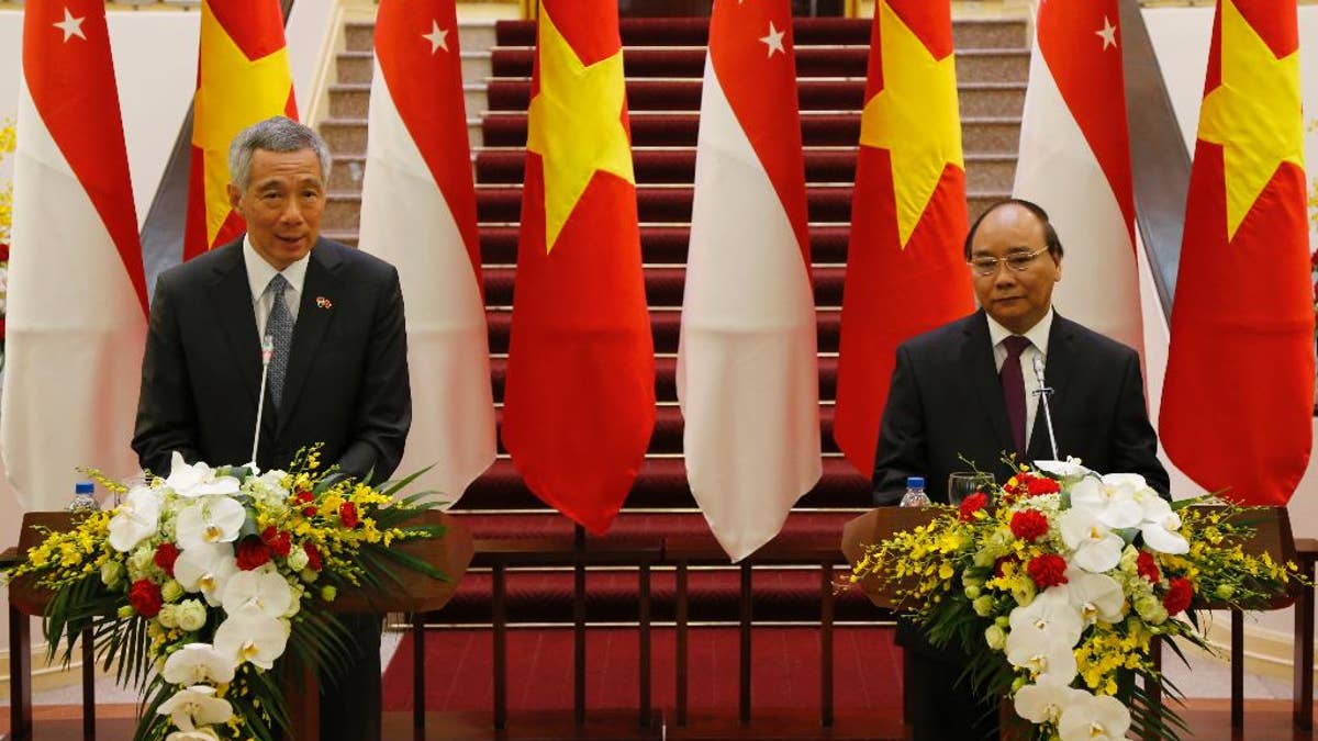 Singapore Prime Minister Lee Hsien Loong, left, speaks during a joint press briefing with his Vietnamese counterpart Nguyen Xuan Phuc in Hanoi, Vietnam, Thursday, March 23, 2017. Lee is on a four-day visit to Vietnam to boost bilateral ties. (AP Photo/Tran Van Minh)