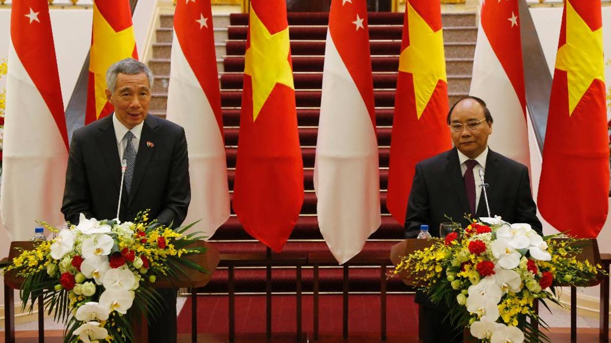 Singapore Prime Minister Lee Hsien Loong, left, speaks during a joint press briefing with his Vietnamese counterpart Nguyen Xuan Phuc in Hanoi, Vietnam, Thursday, March 23, 2017. Lee is on a four-day visit to Vietnam to boost bilateral ties. (AP Photo/Tran Van Minh)