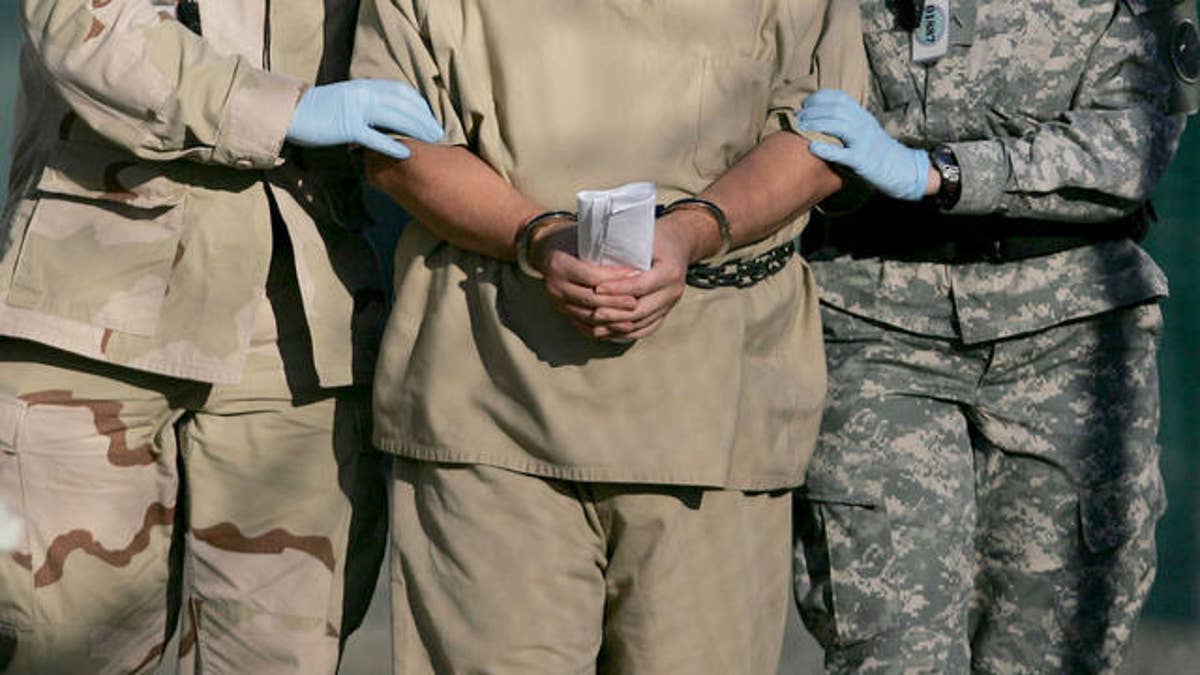 In this photo, reviewed by a U.S. Dept of Defense official, a shackled detainee is transported away from his annual Administrative Review Board hearing with U.S. officials, at Camp Delta detention center, Guantanamo Bay U.S. Naval Base, Cuba, Wednesday, Dec. 6, 2006. Each Guantanamo detainee has the option to participate in his own annual status review hearing which is part of the process for determining if a given detainee will continue to be held for another year. (AP Photo/Brennan Llinsley)
