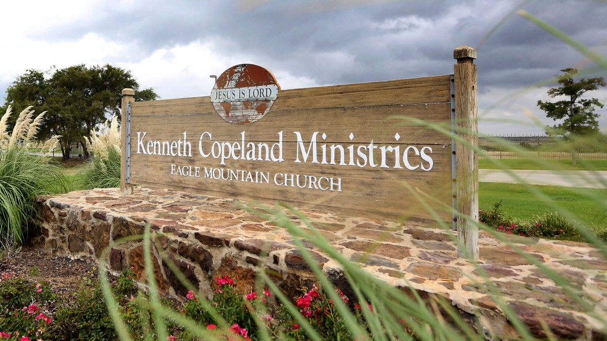 A sign marks the entrance of the Kenneth Copeland Ministries Eagle Mountain Church, Tuesday, Aug. 27, 2013, in Newark, Texas.  The Texas megachurch is linked to at least 21 cases of measles and has been trying to contain the outbreak by hosting vaccination clinics, officials said. (AP Photo/LM Otero)