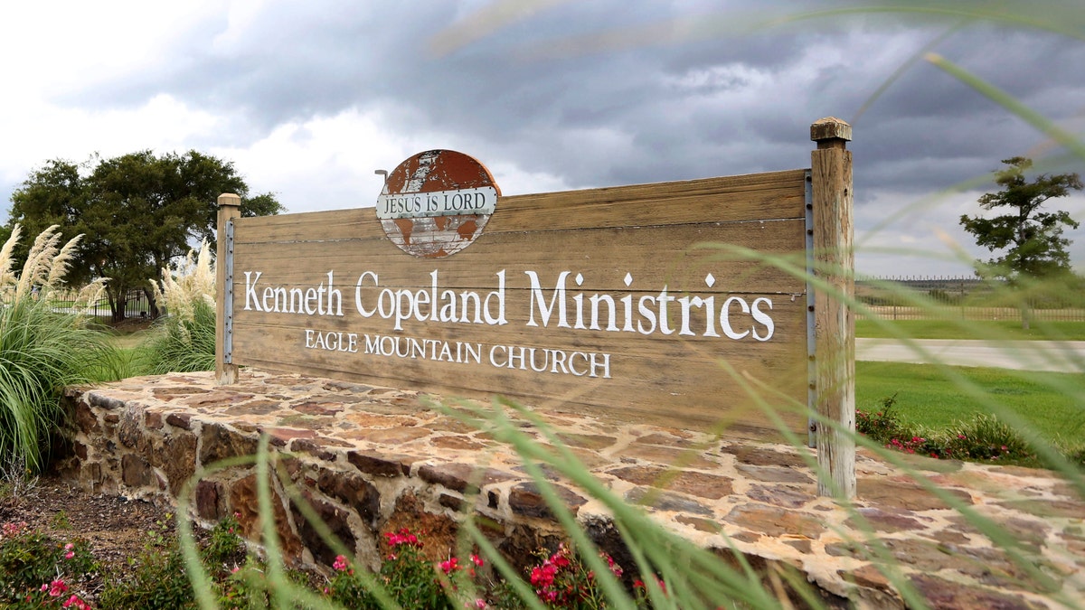 A sign marks the entrance of the Kenneth Copeland Ministries Eagle Mountain Church, Tuesday, Aug. 27, 2013, in Newark, Texas.  The Texas megachurch is linked to at least 21 cases of measles and has been trying to contain the outbreak by hosting vaccination clinics, officials said. (AP Photo/LM Otero)