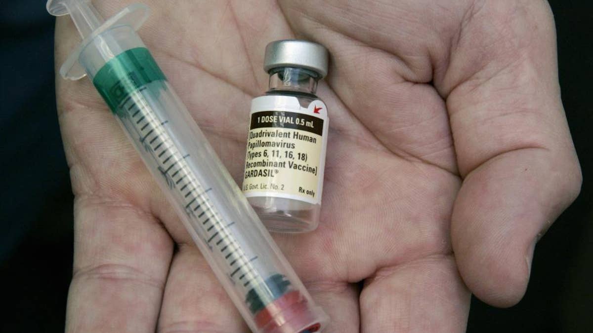 FILE - In this Aug. 28, 2006 file photo, a doctor holds a vial of the human papillomavirus (HPV) vaccine Gardasil in his Chicago office. A national estimate suggests that nearly half of U.S. men have mostly silent infections caused by the sexually-transmitted human papilloma virus, and that 1 in 4 has strains linked with several cancers. The study was released Thursday, Jan. 19, 2017. (AP Photo/Charles Rex Arbogast, File)