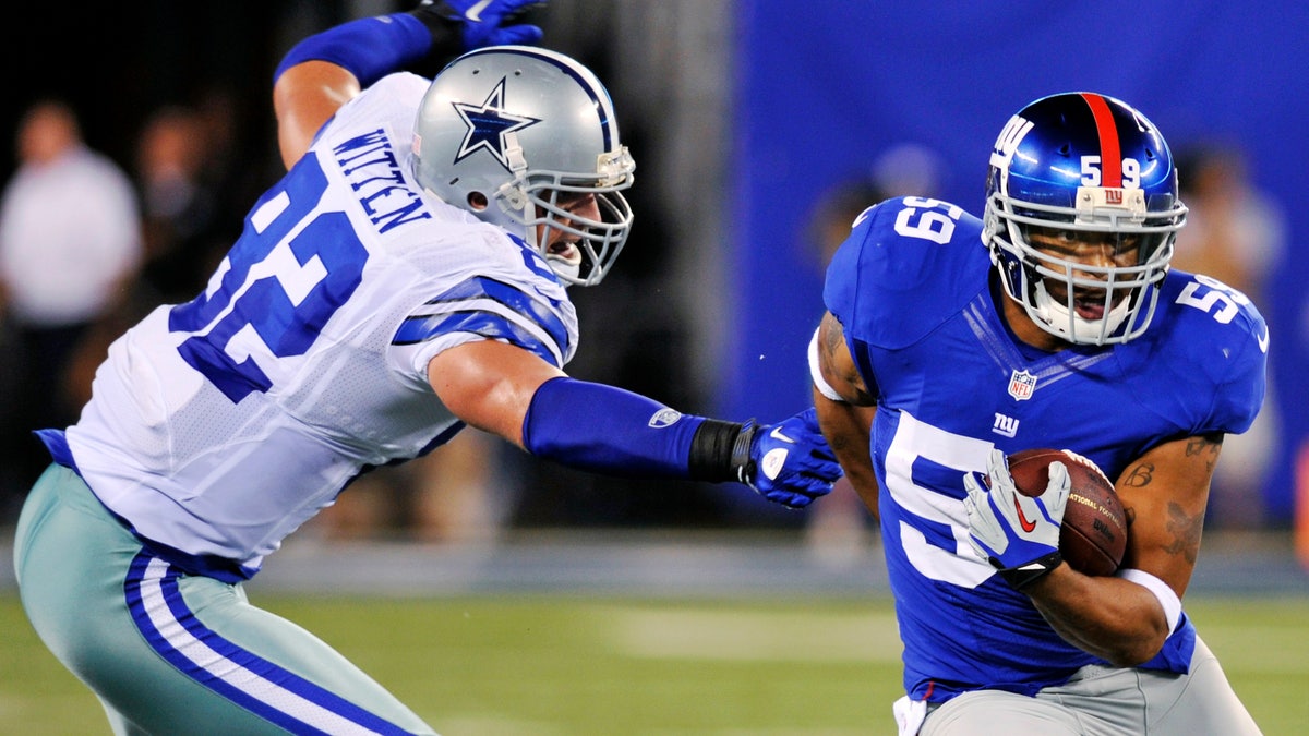 New York Giants linebacker Michael Boley (59) runs back an interception past Dallas Cowboys tight end Jason Witten (82) during the first half of an NFL football game, Wednesday, Sept. 5, 2012, in East Rutherford, N.J. (AP Photo/Bill Kostroun)
