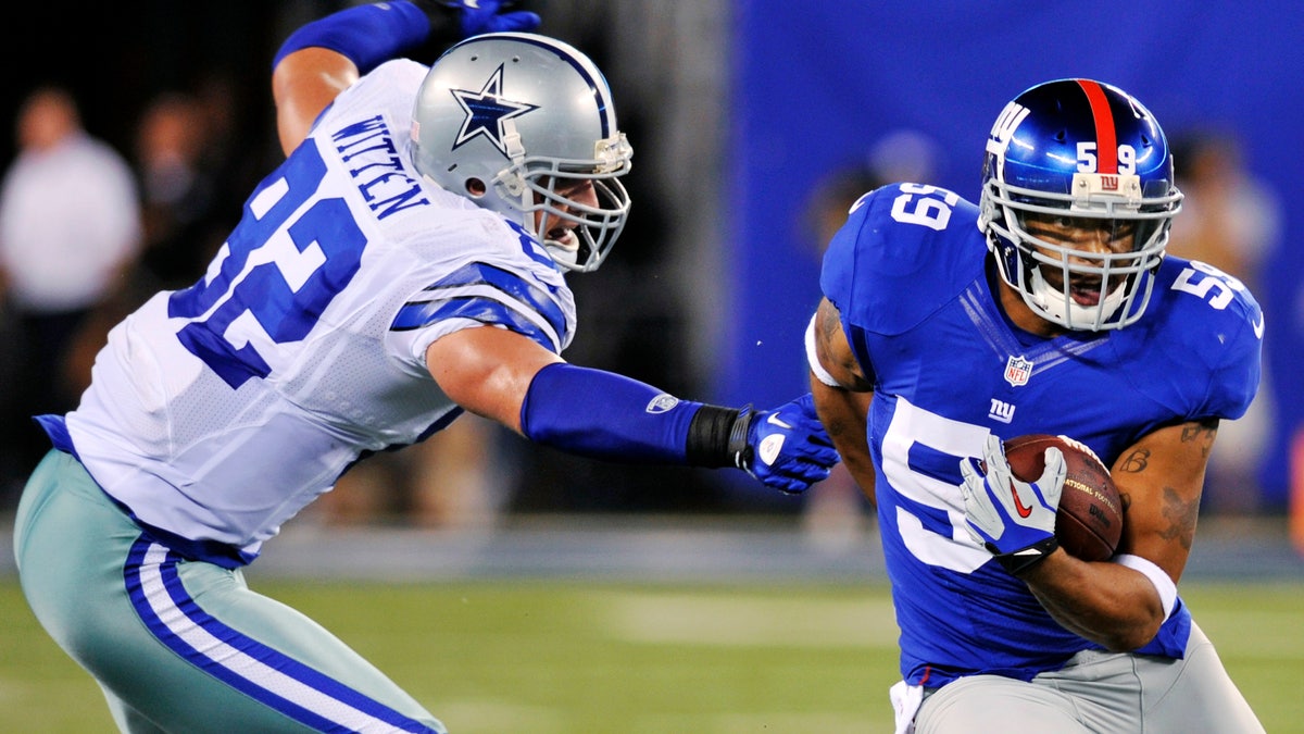 New York Giants linebacker Michael Boley (59) runs back an interception past Dallas Cowboys tight end Jason Witten (82) during the first half of an NFL football game, Wednesday, Sept. 5, 2012, in East Rutherford, N.J. (AP Photo/Bill Kostroun)