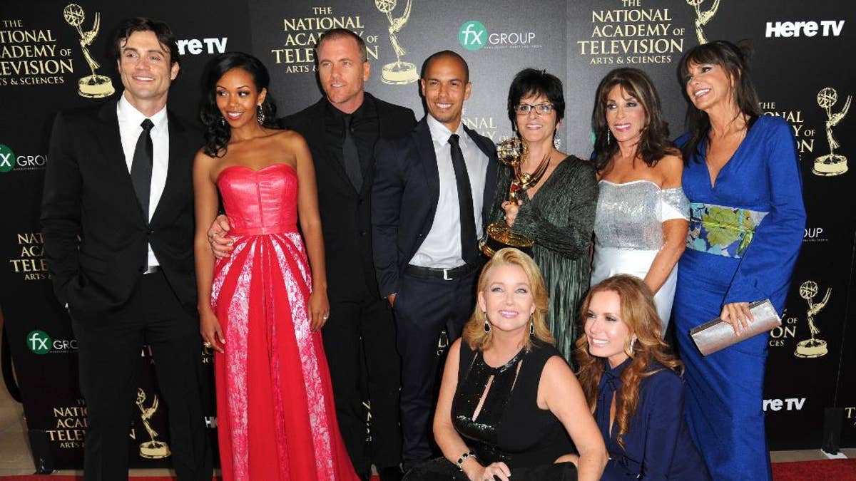 The cast and crew of “The Young and the Restless” poses in the press room with the award for outstanding drama series at the 41st annual Daytime Emmy Awards in 2014.