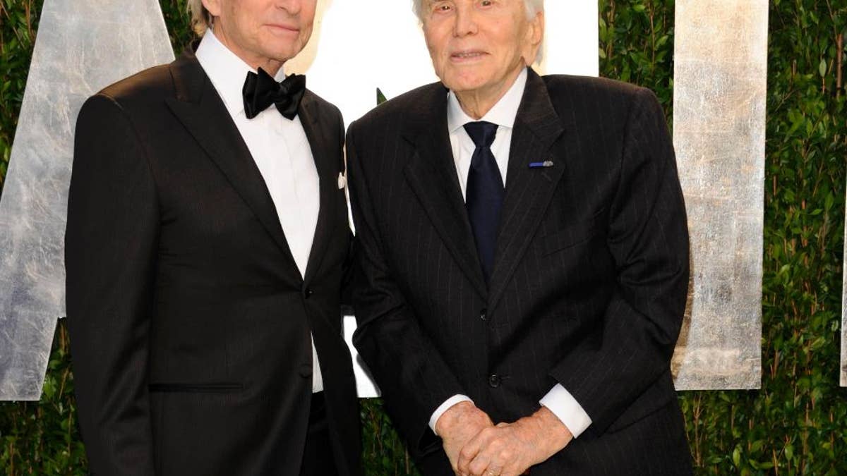 FILE - In this Feb. 26, 2012 file photo, Michael Douglas, left, and Kirk Douglas arrive at the Vanity Fair Oscar party in West Hollywood, Calif. Kirk Douglas has received an early 100th birthday present — an award from the World Jewish Congress for his strong support for Israel, including starring in the first Hollywood feature film shot in the newly established nation. Oscar-winning actor and producer Michael Douglas accepted the award at a dinner at the Pierre Hotel on Wednesday, Nov. 9, 2016, telling over 400 guests that his father will be 