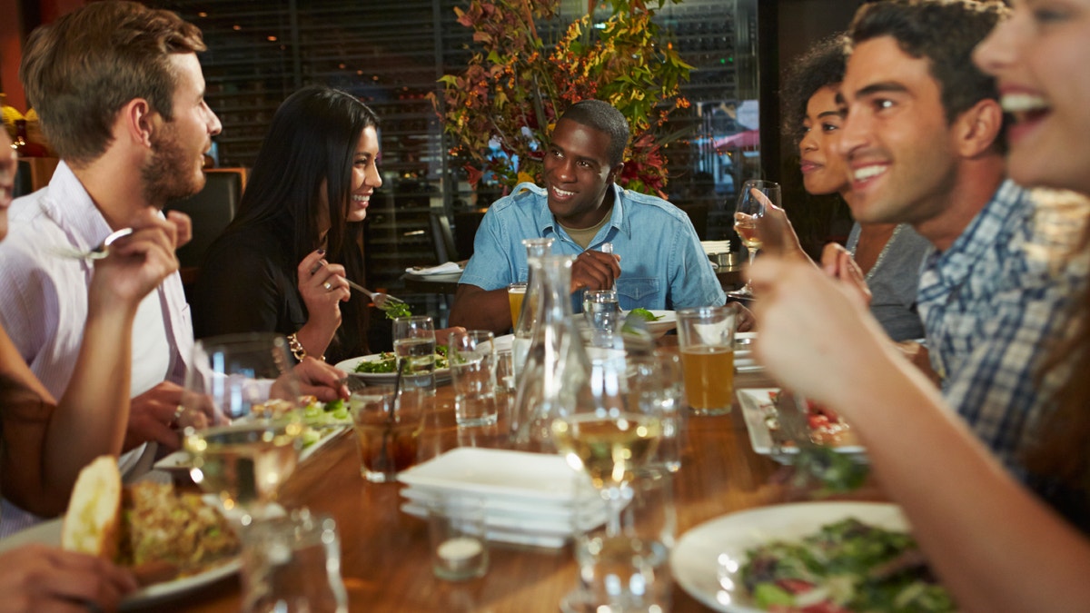 445d3b6f-Group Of Friends Enjoying Meal In Restaurant