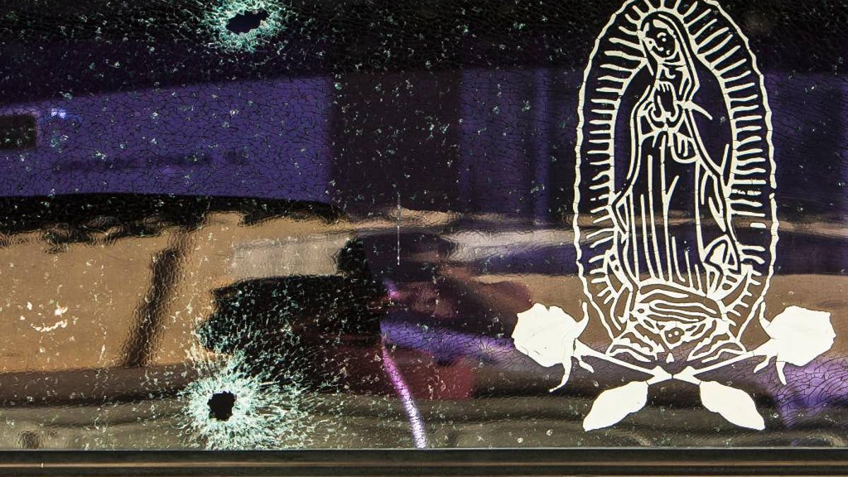 The rear windshield of a vehicle is held together by a transparent film with an image of the Virgin of Guadalupe, after being struck by a couple of bullets in Culiacan, Mexico, Tuesday, Feb. 7, 2017. The Sinaloa state prosecutor’s office said in a statement that several suspects and a Mexican marine died in an early morning clash after heavily armed men attacked the marines while on patrol in the city. (AP Photo/Rashide Frias)