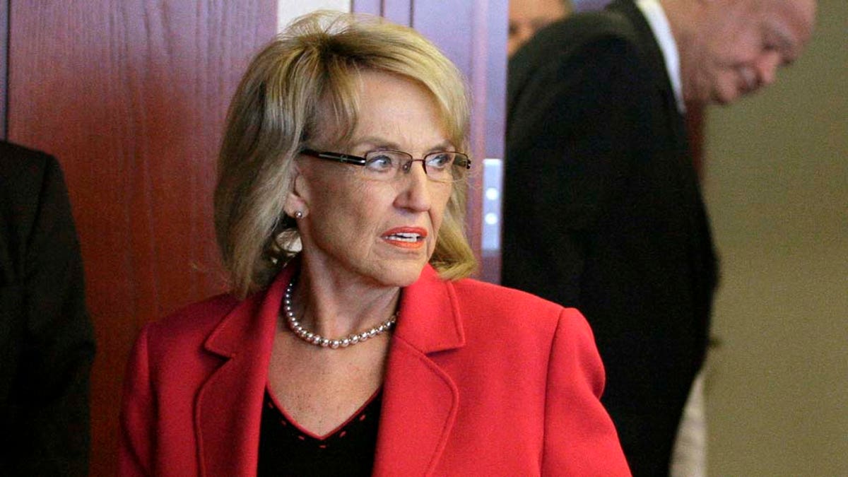 Arizona Gov. Jan Brewer, left, and Arizona Attorney General Tom Horne, back, arrive for a news conference where they announced the state's decision to appeal to the United States Supreme Court by July 11, a decision by a lower court that put the most controversial parts of the state's immigration enforcement law on hold, Monday, May 9, 2011, in Phoenix. (AP Photo/Ross D. Franklin)