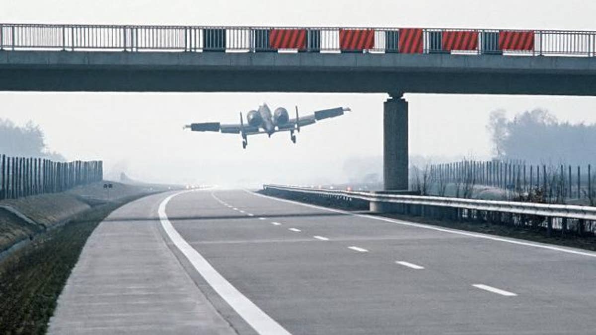 German autobahn with plane landing on it