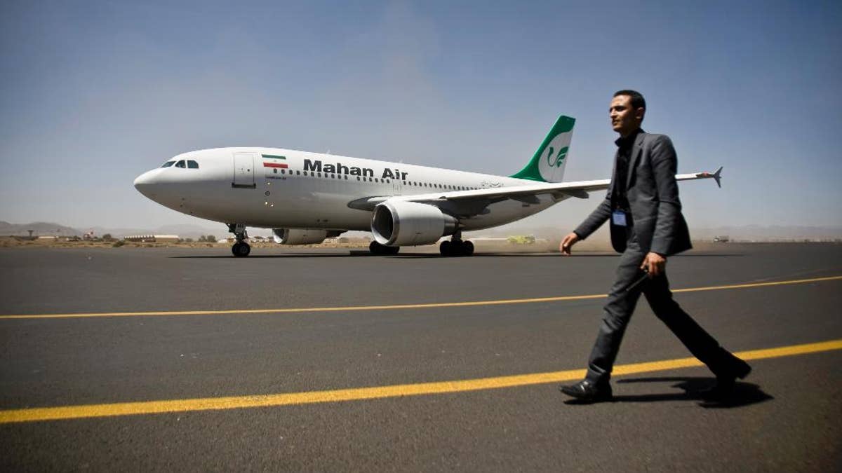 A Yemeni airport security official walks on the tarmac next to a plane from the Iranian private airline Mahan Air at the international airport in Sanaa, Yemen, Sunday, March 1, 2015. The first direct flight from Iran to the rebel-held Yemeni capital arrived, Sunday, an Airbus 310 carrying Iranians including aid workers from the Iranian Red Crescent as Yemen's Shiite rebels formalize ties with the regional Shiite powerhouse. The rebels, who overran the capital, Sanaa, last September, are widely believed to have support from Iran, a claim they frequently denied. (AP Photo/Hani Mohammed)