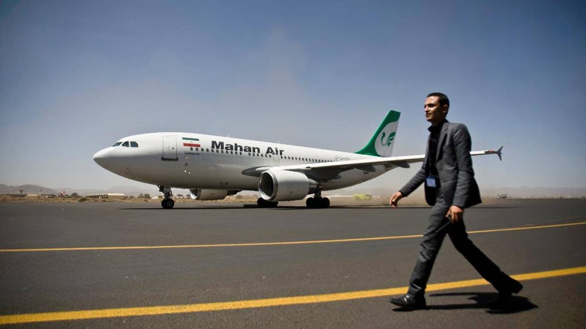 A Yemeni airport security official walks on the tarmac next to a plane from the Iranian private airline Mahan Air at the international airport in Sanaa, Yemen, Sunday, March 1, 2015. The first direct flight from Iran to the rebel-held Yemeni capital arrived, Sunday, an Airbus 310 carrying Iranians including aid workers from the Iranian Red Crescent as Yemen's Shiite rebels formalize ties with the regional Shiite powerhouse. The rebels, who overran the capital, Sanaa, last September, are widely believed to have support from Iran, a claim they frequently denied. (AP Photo/Hani Mohammed)