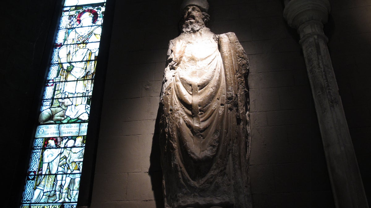 This January 2, 2014 photo shows a statue of St. Patrick in St. Patrick's Cathedral, Dublin. The stained glass window depicts the life of the fifth-century saint who brought Christianity to Ireland. (AP Photo/Helen O?Neill)