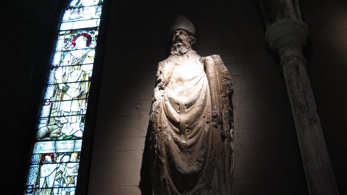 This January 2, 2014 photo shows a statue of St. Patrick in St. Patrick's Cathedral, Dublin. The stained glass window depicts the life of the fifth-century saint who brought Christianity to Ireland. (AP Photo/Helen ONeill)