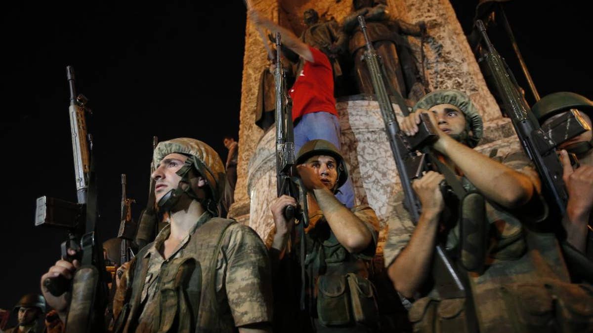 FILE - In this Saturday, July 16, 2016 file photo, Turkish soldiers secure Istanbul's Taksim square, as supporters of Turkey's President Recep Tayyip Erdogan protest in Istanbul. In the wake of last year’s coup in Turkey, scores of military officers are seeking asylum in Belgium and elsewhere in Europe. Three who spoke to AP tell Kafkaesque tales of a life in hiding, charged with crimes against the state. (AP Photo/Emrah Gurel, File)
