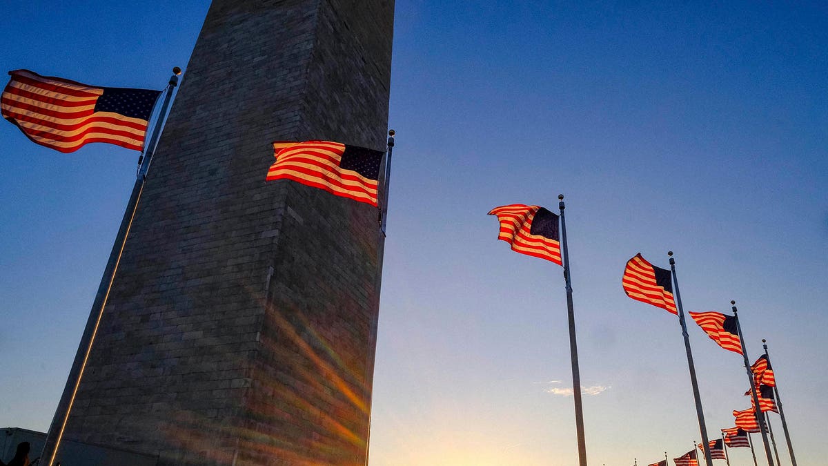 Tourists walk around the base of the Washington Monument on Presidents Day weekend as the sunsets Sunday, Feb. 19, 2017, in Washington. (AP Photo/J. David Ake)