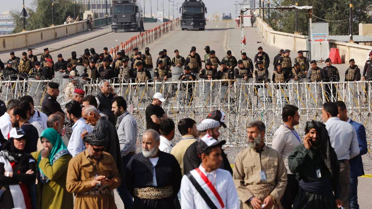 Iraqi riot police close a bridge leading to the heavily guarded Green Zone during a demonstration of supporters of Iraq's influential Shiite cleric Muqtada al-Sadr against corruption in Tahrir Square in Baghdad, Iraq, Friday, March 24, 2017. Al-Sadr has threatened to boycott the upcoming provincial elections, urging instead followers to join a 