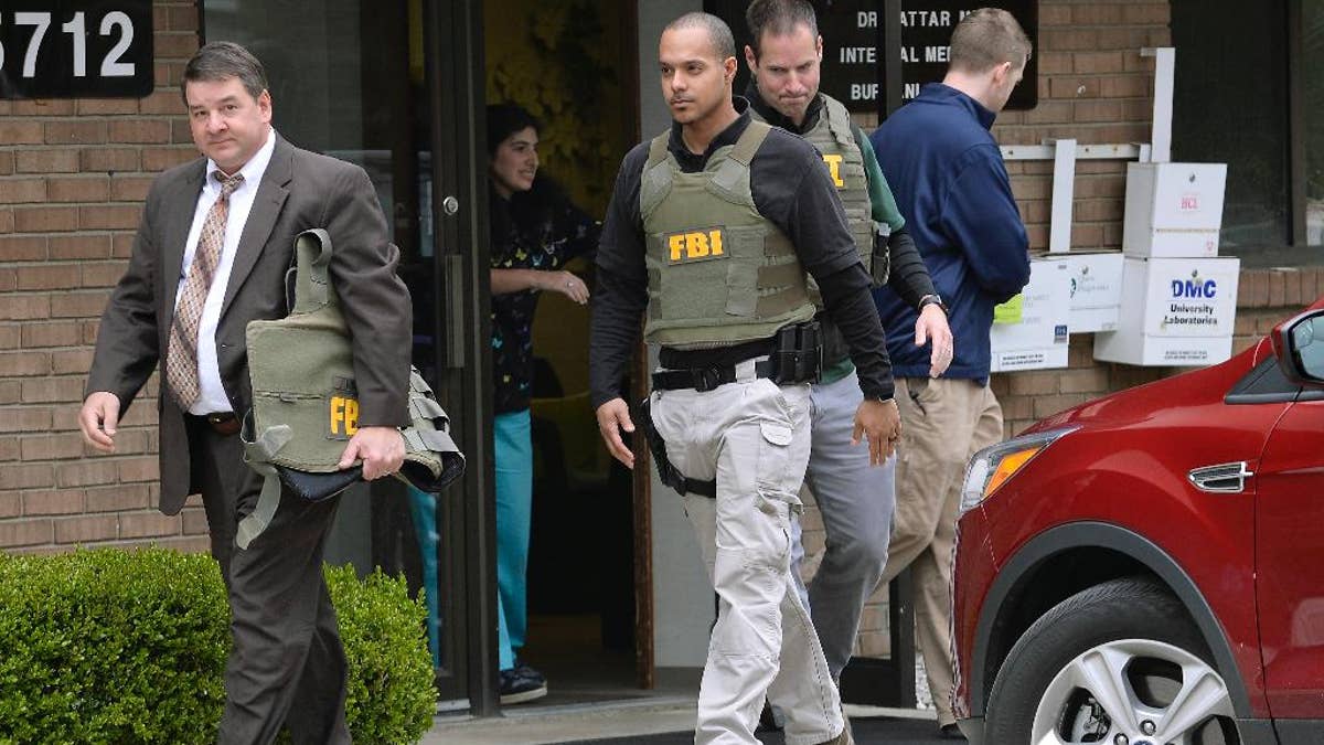 FBI agents leave the office of Dr. Fakhruddin Attar at the Burhani Clinic in Livonia, Mich. Friday, April 21, 2017, after completing a search for documents. The investigation is connected to the case of Dr. Jumana Nagarwala, of Northville, charged with performing genital mutilation on two young girls from Minnesota. (Clarence Tabb Jr. /Detroit News via AP)