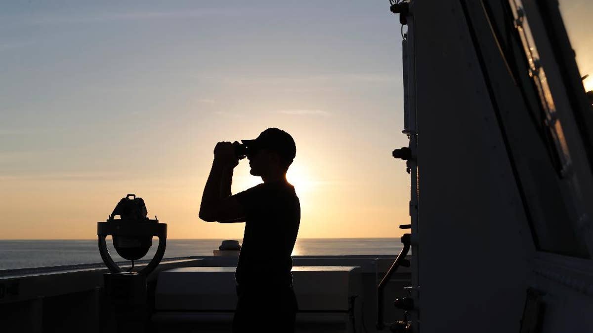 In this Feb. 22, 2017 photo, a U.S. Coast Guard sailor scans the horizon with his binoculars just outside the bridge of the USCG cutter Stratton as it navigates the eastern Pacific Ocean near the coast of Central America. The Coast Guard set a record in 2016, seizing more than 240 tons of cocaine, but its victories seem doomed to be short-lived. That's because hundreds of miles to the south, in the jungles of Colombia, there's a bumper harvest taking place. And Colombia is virtually the only source of cocaine smuggled by sea in small vessels.(AP Photo/Dario Lopez-Mills)