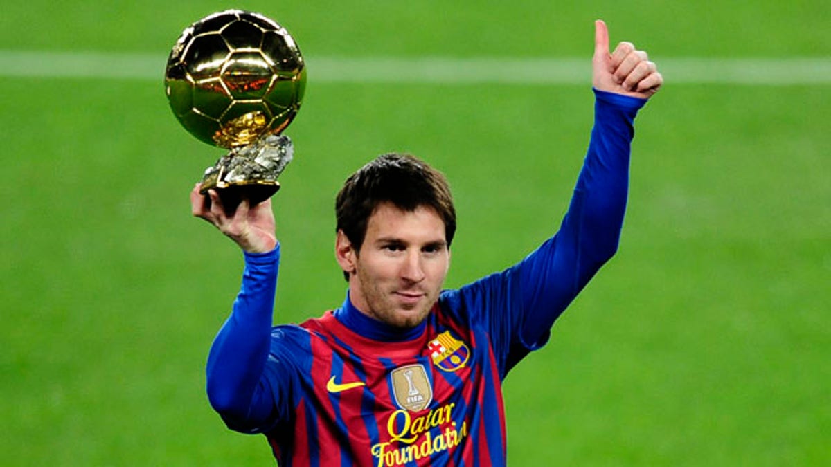 FC Barcelona's Lionel Messi, from Argentina, holds his Ballon d'Or (Golden Ball) award as European Footballer of the Year before a Spanish La Liga soccer match between FC Barcelona and Betis at the Camp Nou stadium in Barcelona, Spain, Sunday, Jan. 15, 2012. (AP Photo/Manu Fernandez)