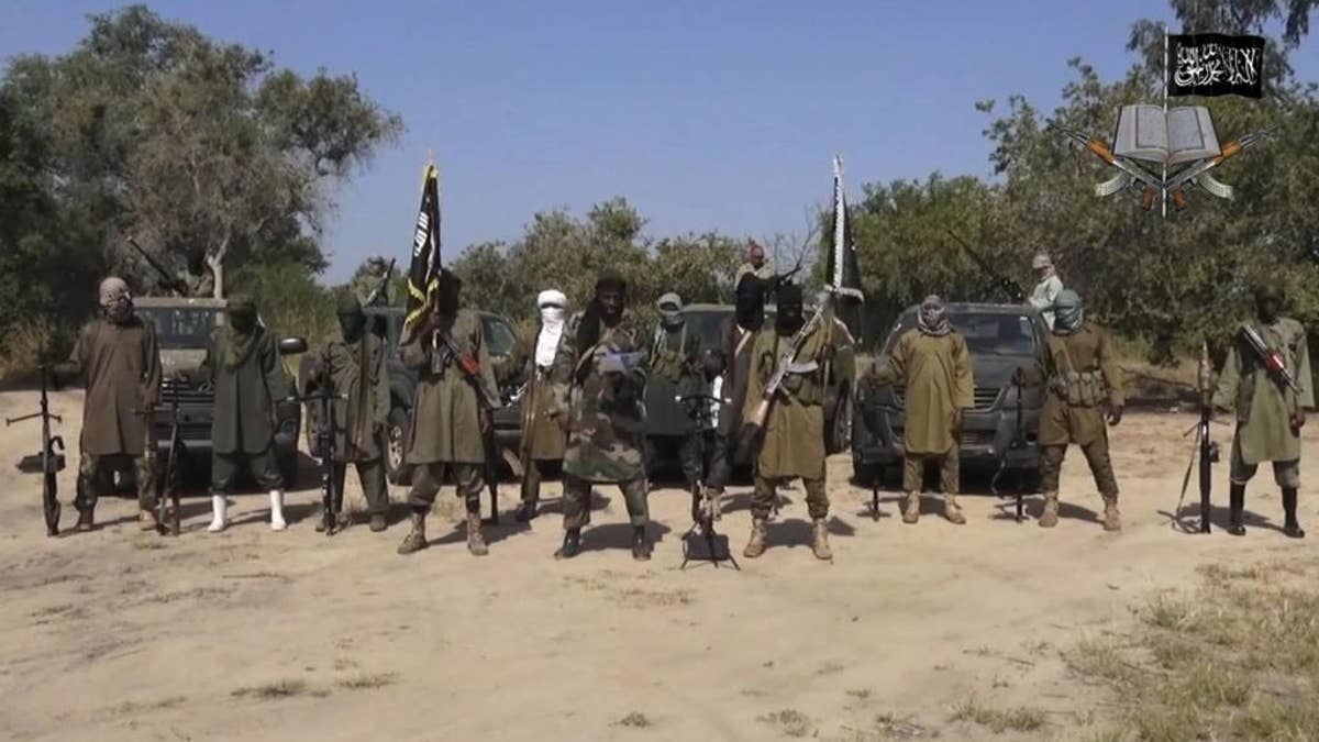 FILE - In his file image taken from video released late Friday evening, Oct. 31, 2014, by Boko Haram, Abubakar Shekau, centre, the leader of Nigeria's Islamic extremist speaks in an unidentified place. Boko Haram leader Abubakar Shekau is believed to be fatally wounded in an airstrike while he was praying in a forest stronghold in northeast Nigeria, the military said Tuesday Aug. 23, 2016 A statement does not say how the military got the information but it identifies other commanders as "confirmed dead."(AP Photo/Boko Haram,File)