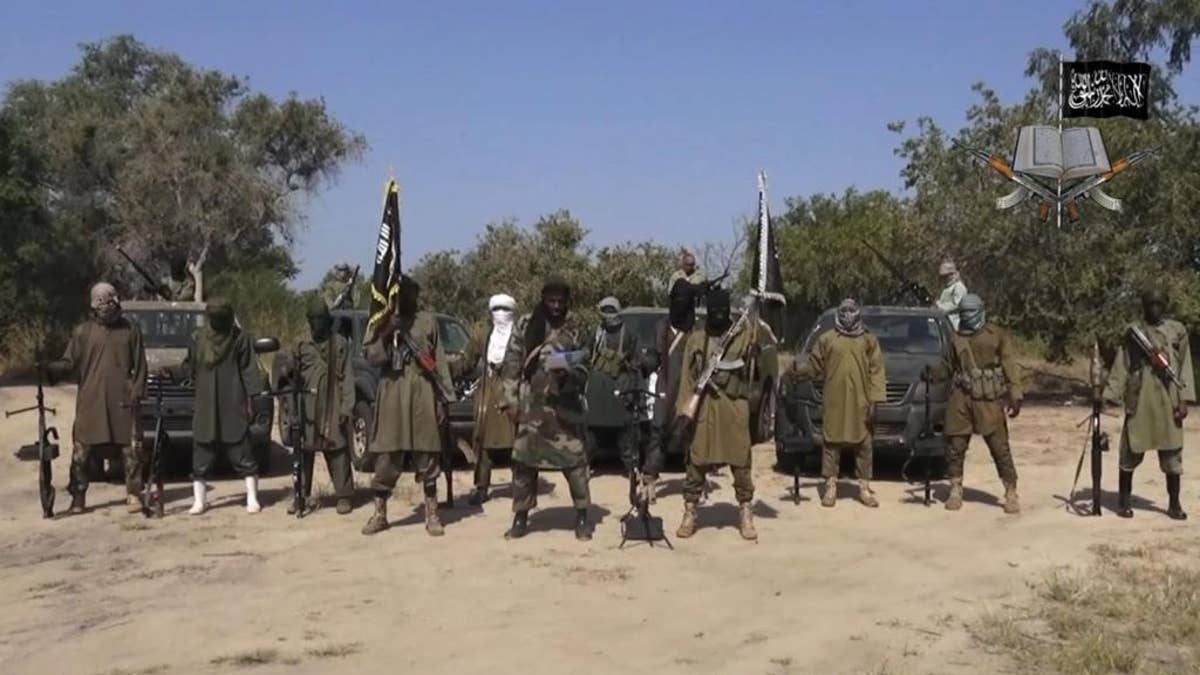 FILE - In his file image taken from video released late Friday evening, Oct. 31, 2014, by Boko Haram, Abubakar Shekau, centre, the leader of Nigeria's Islamic extremist speaks in an unidentified place. Boko Haram leader Abubakar Shekau is believed to be fatally wounded in an airstrike while he was praying in a forest stronghold in northeast Nigeria, the military said Tuesday Aug. 23, 2016 A statement does not say how the military got the information but it identifies other commanders as "confirmed dead."(AP Photo/Boko Haram,File)