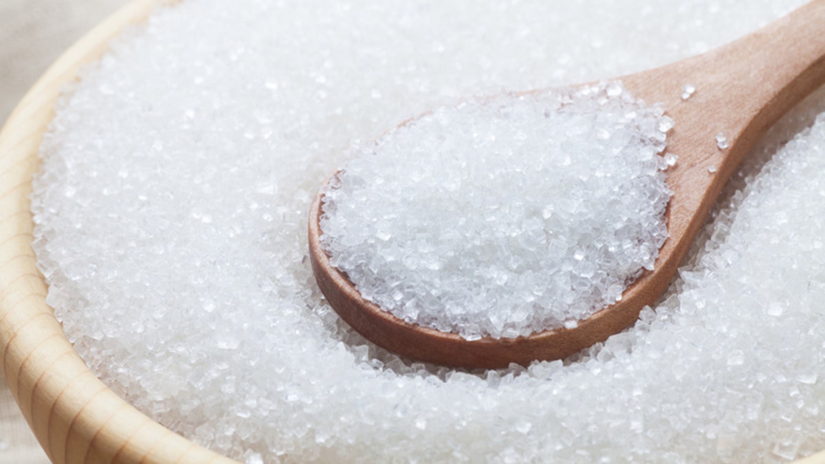 White sugar with spoon in wooden bowl, Close-up.