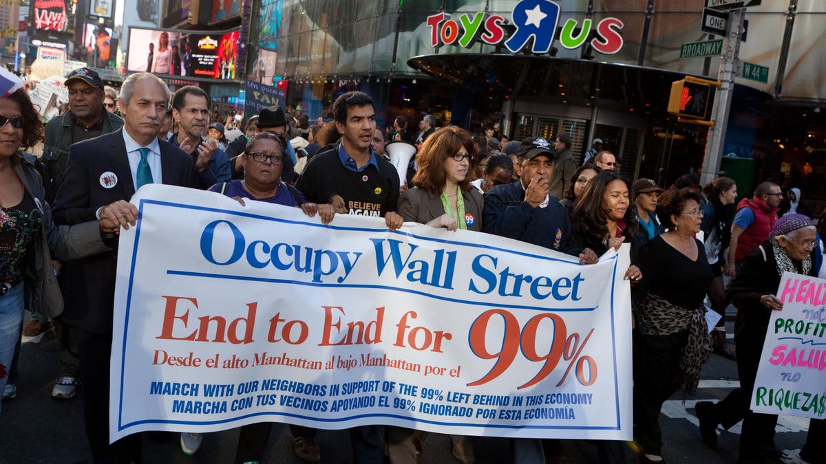 Demonstrators affiliated with the Occupy Wall Street protests walk through Times Square during an 11-mile march from uptown Manhattan to Zuccotti Park, Monday, Nov. 7, 2011, in New York. Elected officials, labor leaders and other protesters started walking in Washington Heights to show solidarity with the Occupy Wall Street movement. (AP Photo/John Minchillo)