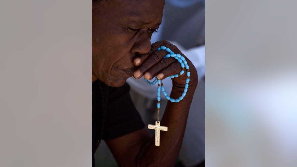 A woman holds a rosary as she prays during a mass at the Cathedral in Port-au-Prince, Haiti, Wednesday, Jan. 12, 2011. Wednesday marks one year since Haiti's 7.0 magnitude earthquake that devastated the capital and is estimated that have killed more than 230,000 people and left millions homeless.  (AP Photo/Ramón Espinosa)