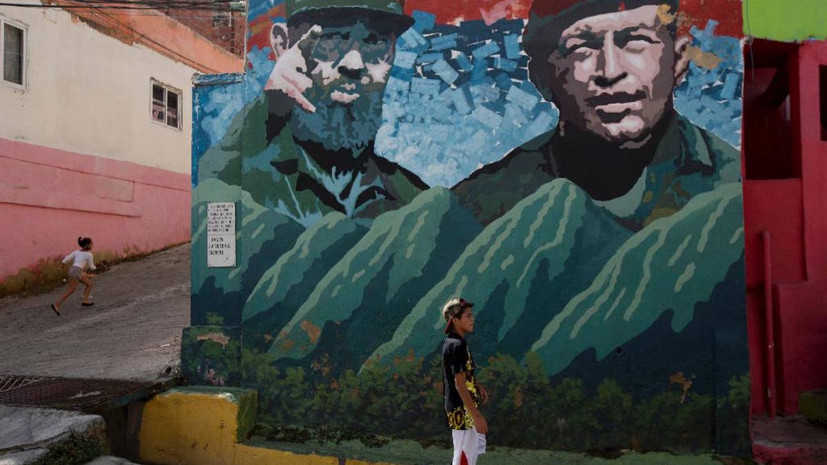 Boys play near a graffiti of Fidel Castro, left, and late President of Venezuela Hugo Chavez at "23 de Enero" neighborhood in Caracas, Venezuela, Saturday, Nov. 26, 2016. Castro, who led a rebel army to improbable victory, embraced Soviet-style communism and defied the power of 10 U.S. presidents during his half century rule of Cuba, died at age 90. (AP Photo/Fernando Llano)