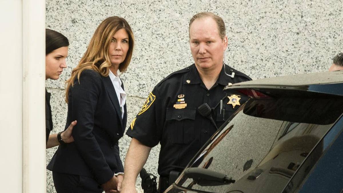 CORRECTS TO AFTER SENTENCING HEARING, NOT BEFORE - Former Pennsylvania Attorney General Kathleen Kane is escorted from Montgomery County courthouse after her sentencing hearing in Norristown, Pa, Monday, Oct. 24, 2016. Kane was sentenced Monday to 10 to 23 months in jail for illegally disclosing details from a grand jury investigation to embarrass a rival and lying about it under oath. (AP Photo/Matt Rourke)