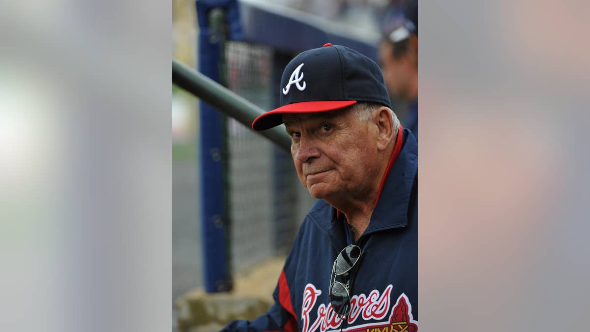 Former Atlanta Braves manager Bobby Cox watches from the dugout as he manages the minor league Future Stars against the Atlanta Braves in an exhibition baseball game Saturday, March 29, 2014, in Rome, Ga. (AP Photo/David Tulis)